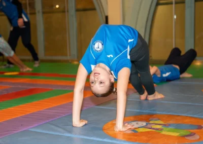 Child performing bridge pose during Christmas gymnastics event in Kensington London