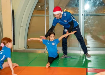 Girls practising middle splits during KCGA Christmas gymnastics class in London