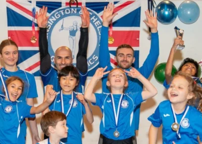 Large group of children and coaches with medals at London gymnastics club Christmas event