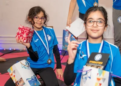 Gymnasts holding Christmas presents and gift bags at KCGA Knightsbridge 2024