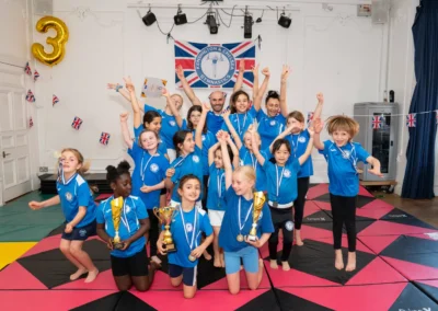 Knightsbridge gymnasts celebrating with trophies and medals at KCGA Annual Performance 2025 in London SW1X