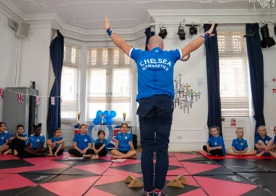 Coach Stefan performing a gymnastics demonstration in front of children at KCGA Annual Performance 2025 in Knightsbridge London at More House School SW1X