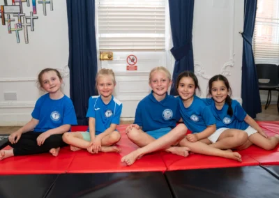 Group of young girls sitting on mats at KCGA Annual Performance 2025 in Knightsbridge London SW1X