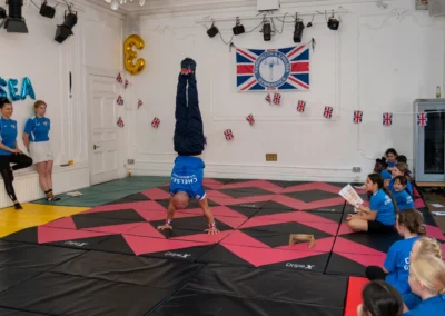 Coach Stefan performing a handstand demonstration at KCGA Annual Performance 2025 in Knightsbridge London SW1X
