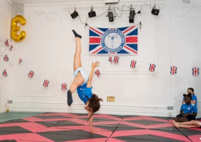 Young gymnast performing one-handed cartwheel at KCGA Annual Performance Knightsbridge London SW1X
