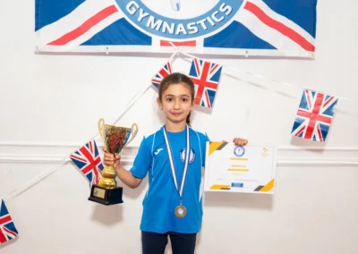Knightsbridge gymnast holding trophy and certificate after winning KCGA Gymnast of the Year 2025 at More House School London SW1X
