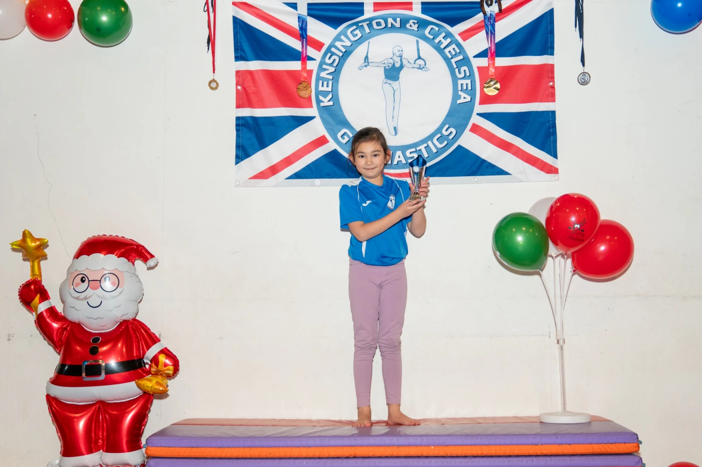 Young gymnast Leonie holding her trophy at KCGA Christmas Awards, London