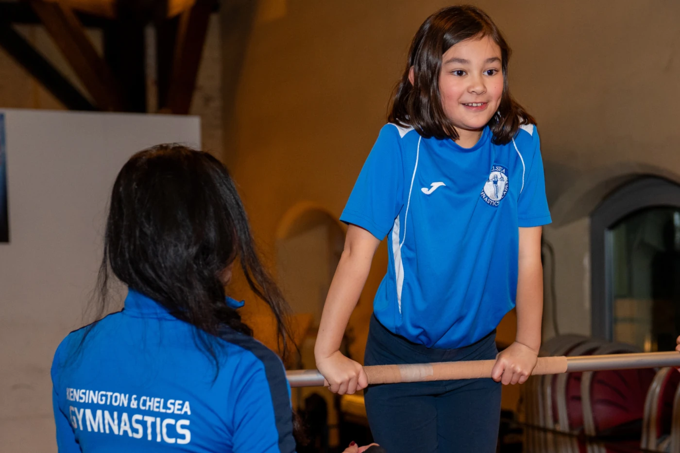 Young gymnast Leonie training on bars at KCGA Christmas Event in Kensington, London