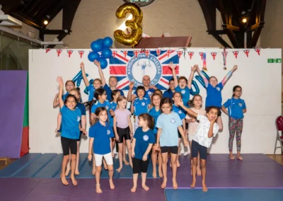 Children celebrating and jumping during KCGA Annual Performance 2025 gymnastics event in Kensington London