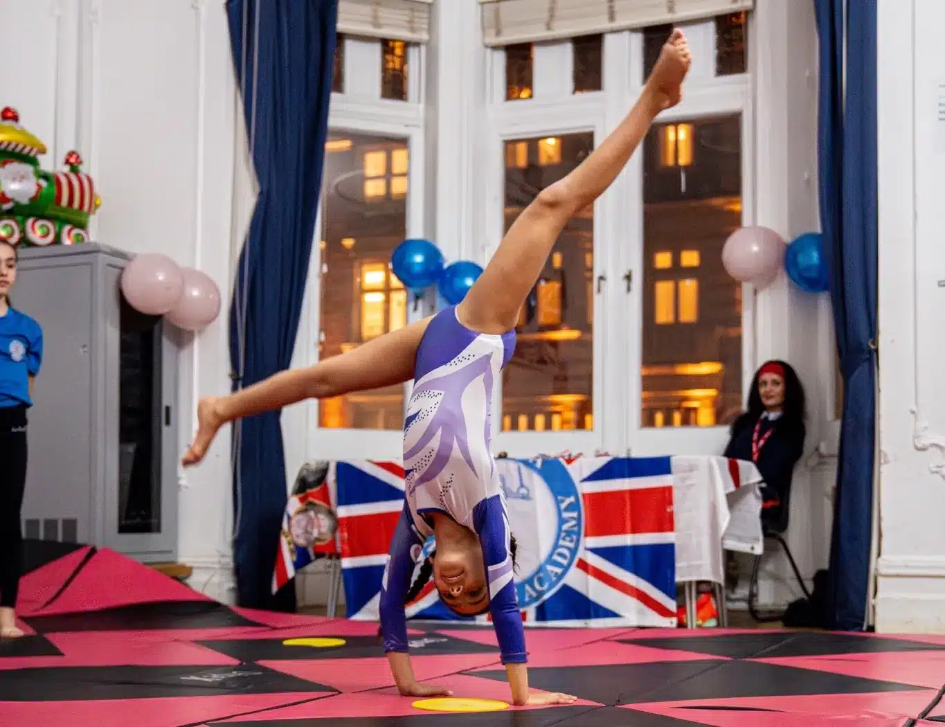 Young gymnast performing a controlled cartwheel during a KCGA showcase event in London