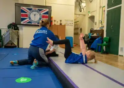 Young girl practising a bent leg dish shape exercise during a KCGA Chelsea gymnastics class