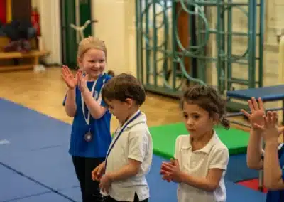 Young children clapping and smiling after receiving medals during KCGA Chelsea gymnastics Easter Week 2026