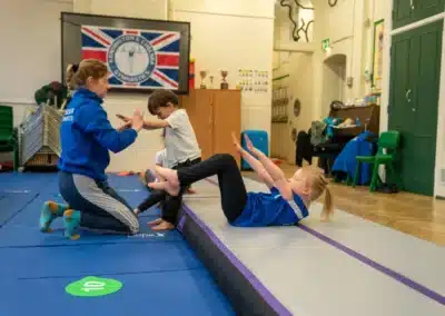 Young girl practising a core strength hold during a KCGA Chelsea gymnastics class