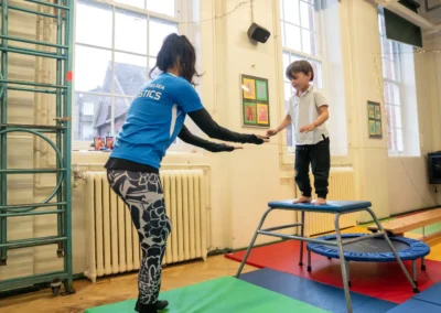 Young boy practising a straight jump from the vault platform during a KCGA Chelsea gymnastics class