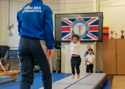 Young child performing a straight jump on the air track during a Chelsea gymnastics class