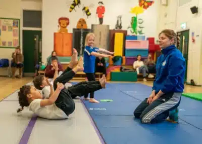 Young children practising tucked rocking shape together during a KCGA Chelsea gymnastics class