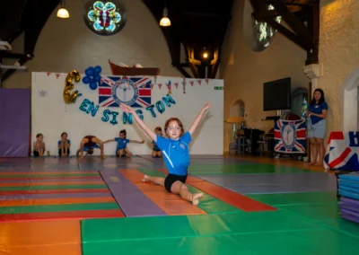 Young girl gymnast performing a front split floor routine at the KCGA Annual Performance 2025 in Kensington, London.