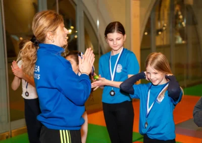 Young gymnasts celebrating and wearing their Easter Week medals after gymnastics class in Kensington