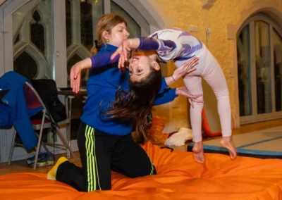 Young gymnast beginning a back handspring with coach support during gymnastics training in Kensington London