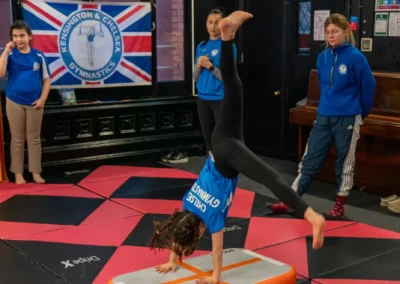 Child performing a cartwheel on an inflatable air track during gymnastics in Knightsbridge London