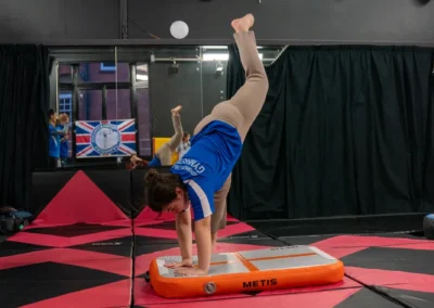Child performing a cartwheel on an air track during gymnastics in Knightsbridge London