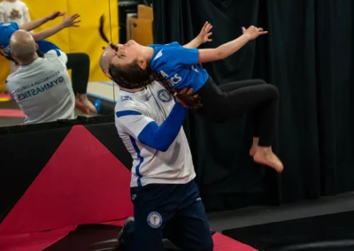 Dr Stefan Kolimechkov supporting a child preparing for a back somersault during gymnastics training in Knightsbridge