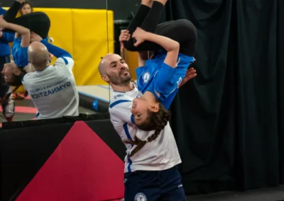 Dr Stefan Kolimechkov spotting a child performing a back tuck somersault during gymnastics in Knightsbridge London