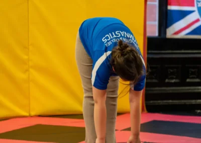 Child performing a forward fold stretch during gymnastics warm up in Knightsbridge London