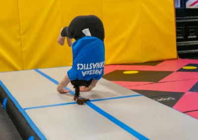 Child performing a forward roll on an air track during gymnastics classes in Knightsbridge London