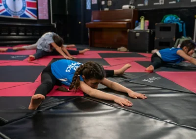 Child performing a seated straddle stretch during gymnastics classes in Knightsbridge London
