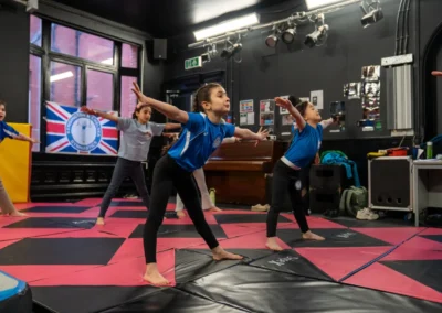 Children performing a balance and warm up exercise during gymnastics classes in Knightsbridge London
