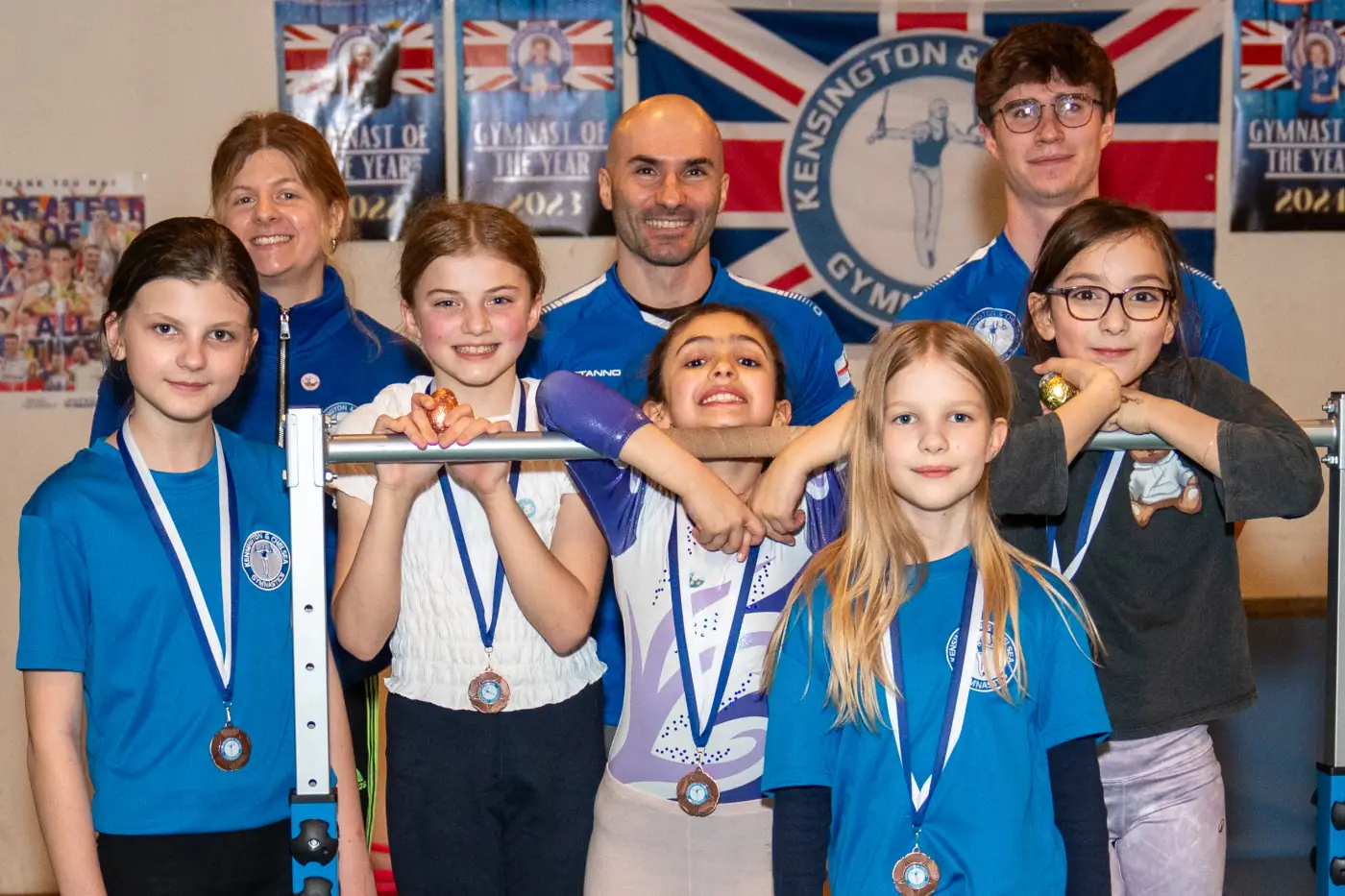 KCGA gymnasts and coaches posing with medals during Easter Sessions at Kensington & Chelsea Gymnastics Academy in London
