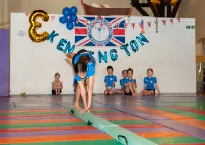 Young gymnast balancing on a beam while performing a gymnastics skill during KCGA Annual Performance 2025 in Kensington.