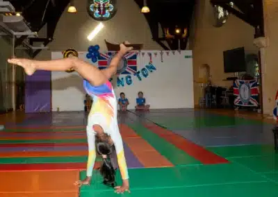 Artistic gymnast performing a walkover during the KCGA Annual Performance 2025 in Kensington, London.