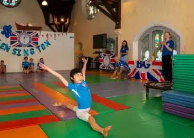 Young gymnast performing front splits during KCGA Annual Performance 2025 in Kensington, London.