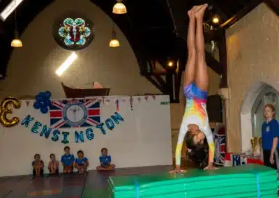 Young gymnast performing handspring half off during KCGA Annual Performance 2025 in Kensington, London.