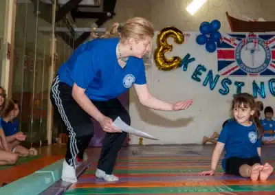 Gymnastics coach encouraging a young gymnast during KCGA Annual Performance 2025 in Kensington.