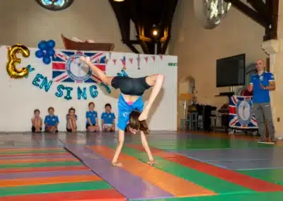 Young gymnast performing a walkover during KCGA Annual Performance 2025 in Kensington, London.