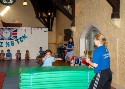 Young gymnast performing vault during KCGA Annual Performance 2025 in Kensington, London.