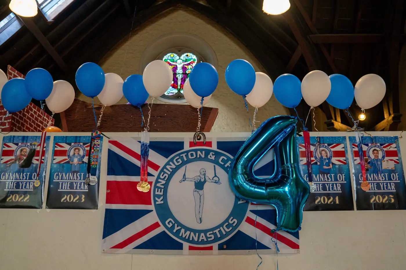 KCGA fourth anniversary display with balloons, Union Jack backdrop and Gymnast of the Year posters at Annual Performance 2026