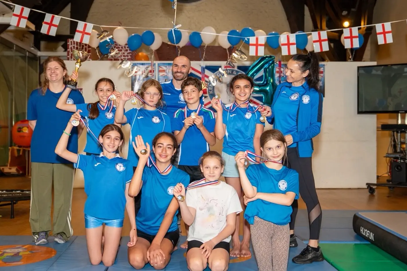 KCGA gymnasts and coaches celebrating with medals after Annual Performance 2026