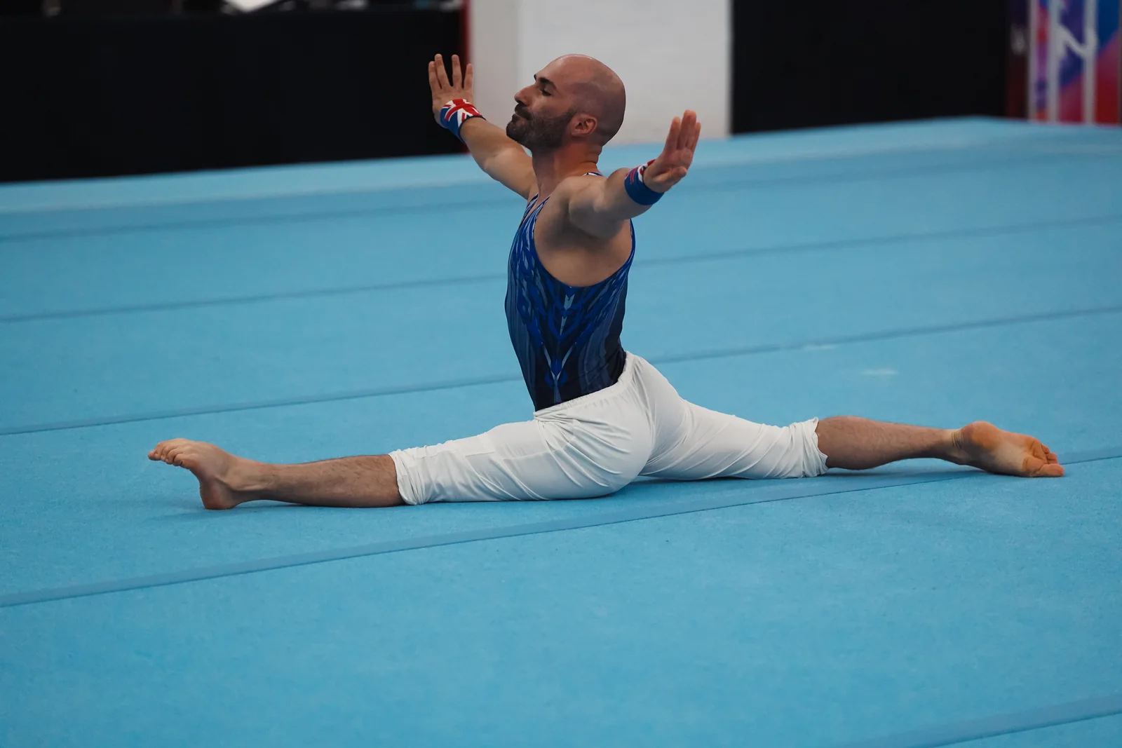 Dr Stefan Kolimechkov performing a split during his floor routine at the 2026 Adult Gymnastics British Championships