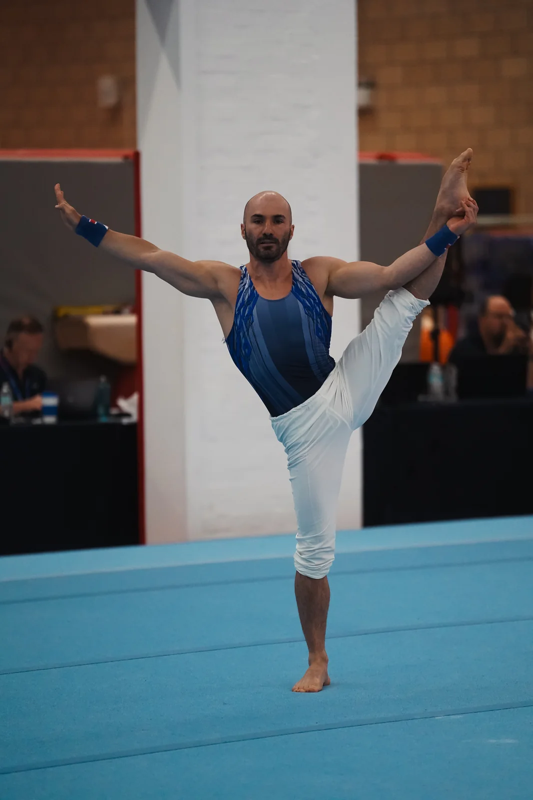 Dr Stefan Kolimechkov performing a Y-balance during his floor routine at the 2026 Adult Gymnastics British Championships