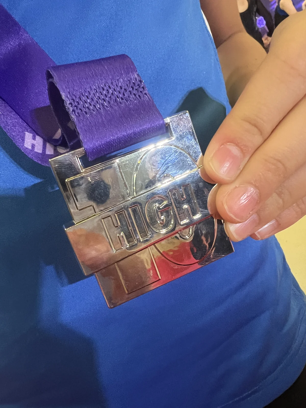 Close-up of Sofia holding KCGA’s first children’s competition medal, a silver medal won in 2025