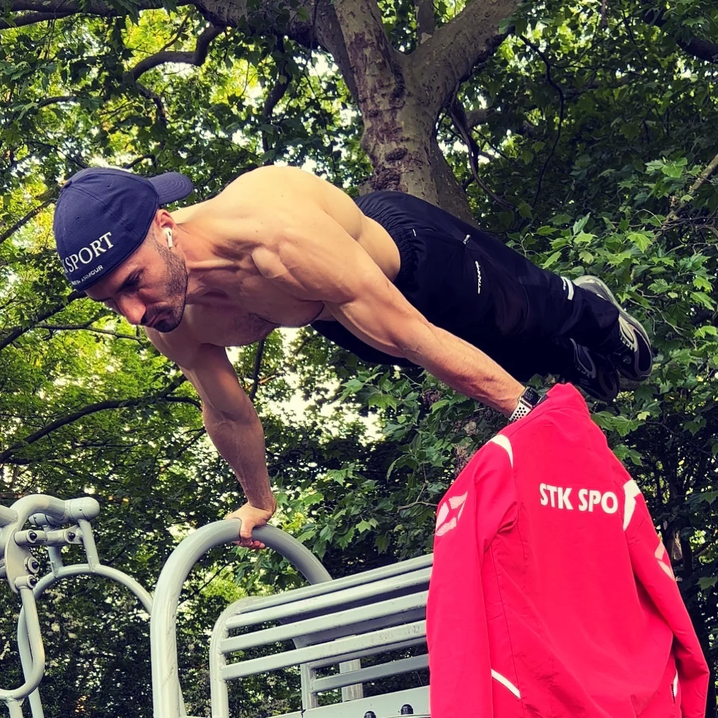 Stefan Kolimechkov performing a top planche on the earlier Holland Park outdoor parallel bars.